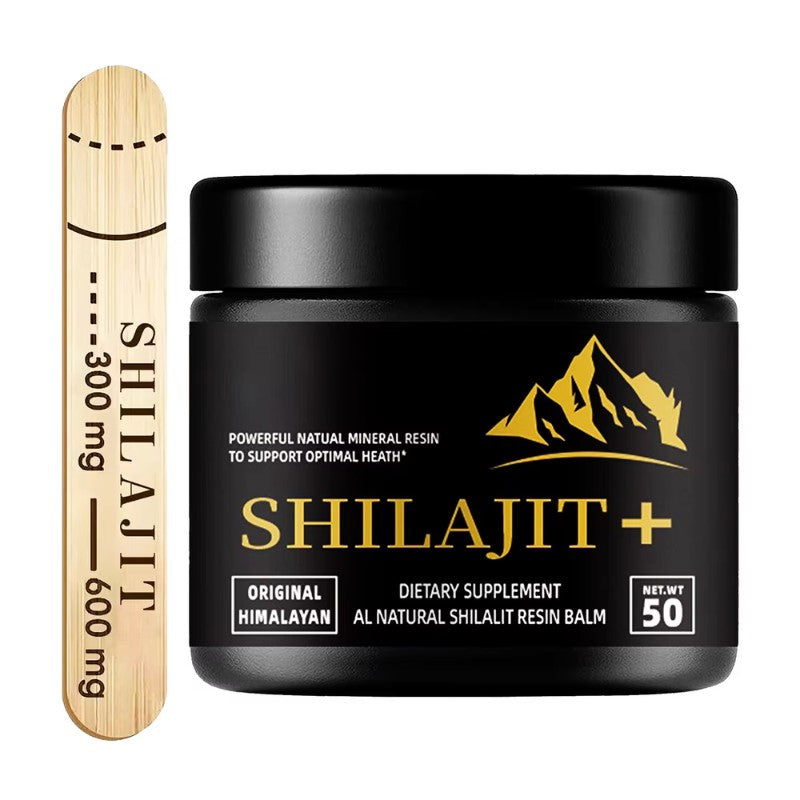 Black Shilajit supplement jar with gold text and mountain logo, accompanied by a wooden scoop tool.