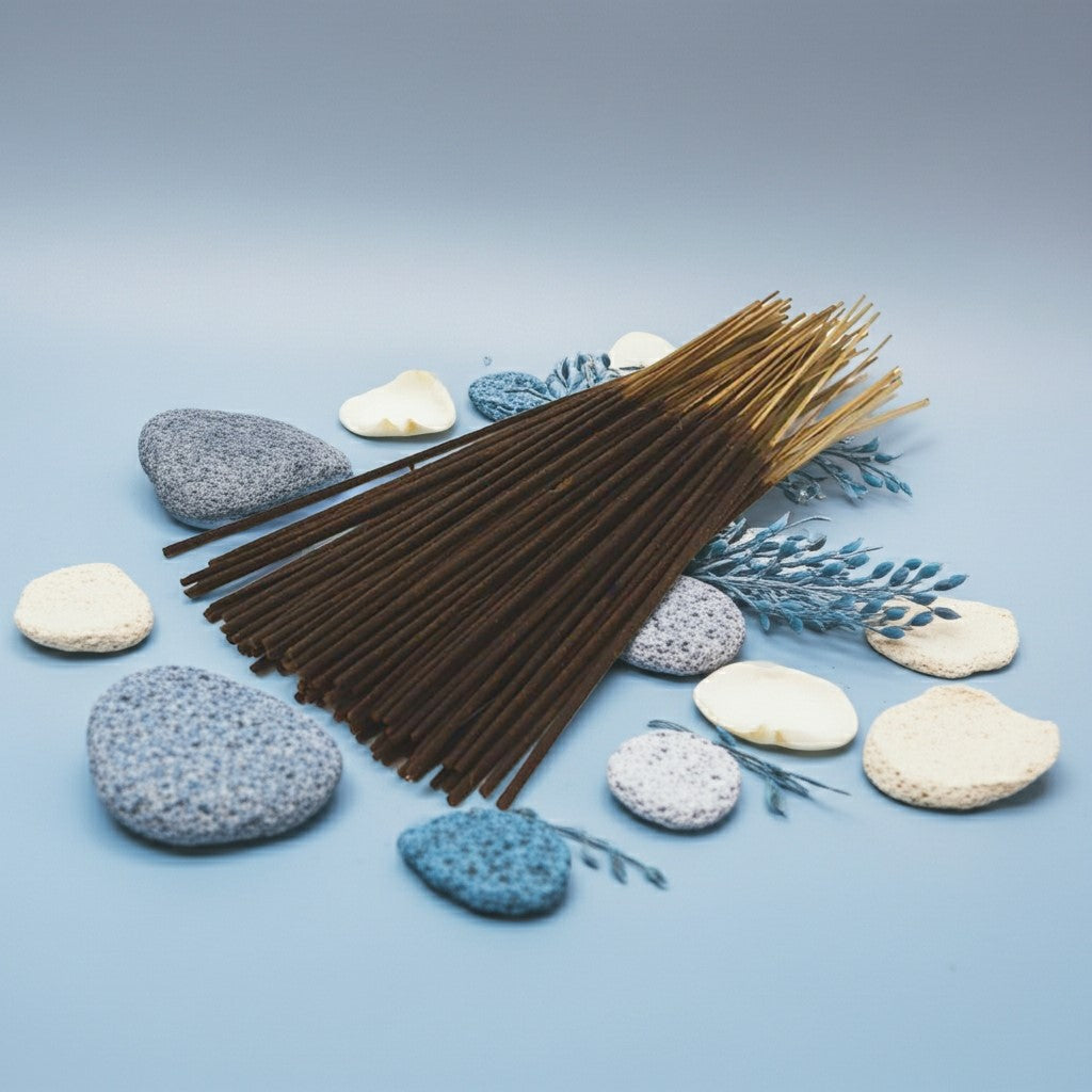 China Rain Incense Sticks with a red ribbon surrounded by stones, flowers, and candles on a light blue background