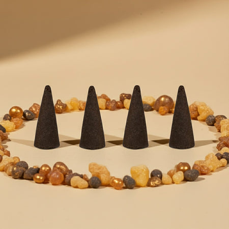 Frankincense Incense Cones on a sandy surface with colorful stones.