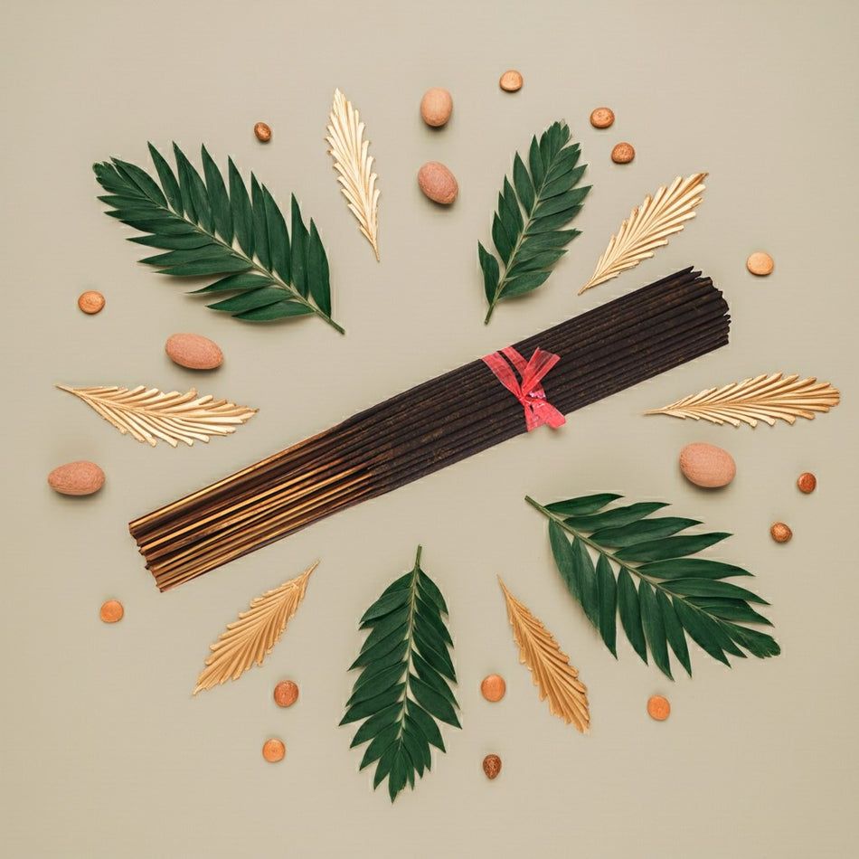 Imported Jannatul Firdaus Incense Sticks with a pink ribbon surrounded by leaves and small round objects on a beige background