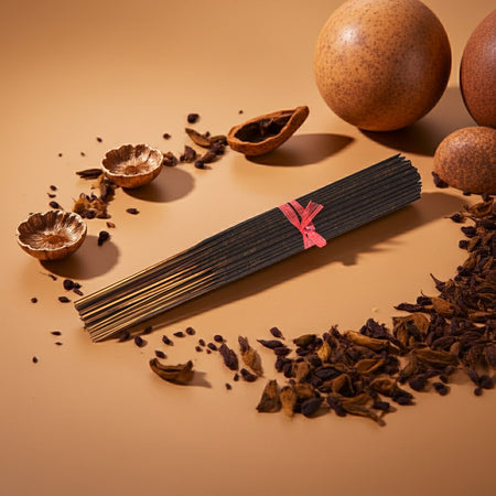 Imported Opium Incense Sticks with a pink label on a beige background with dried fruits and seeds.