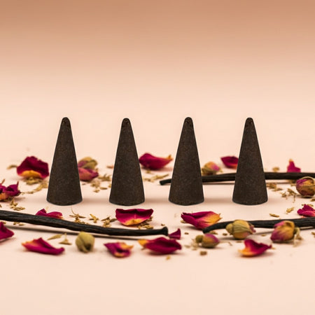 Imported Rose Vanilla Incense Cones on a surface with dried flowers and herbs.