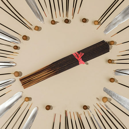 Imported Tahara Musk Incense Sticks with a pink ribbon arranged in a circular pattern on a beige background