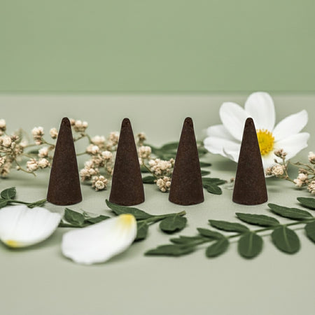 Jasmine Incense Cones on a light green background with white flowers and green leaves.