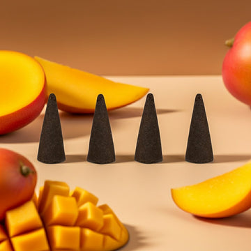 Mango Butter Incense Cones on a surface with mangoes in the background