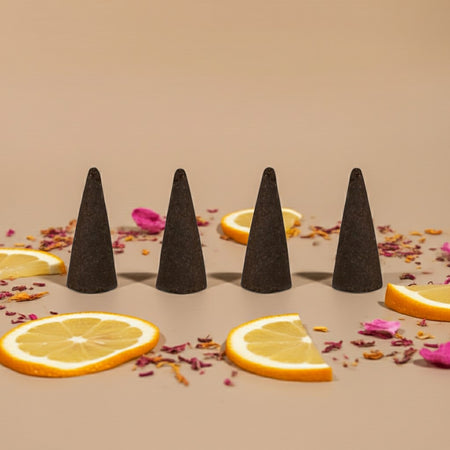 Pink Lemonade Incense Cones on a beige surface with orange slices and pink flowers.