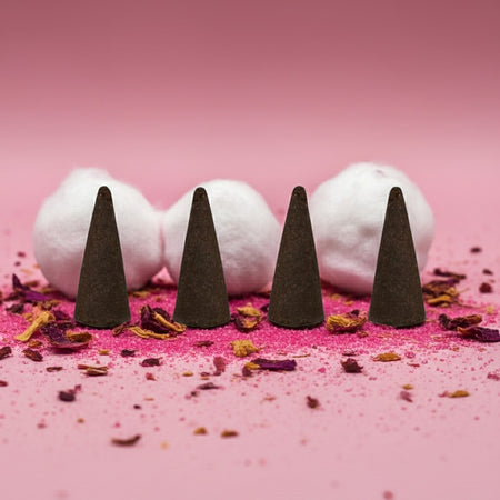 Pink Sugar Incense Cones on a pink surface with white cotton balls and dried flowers.