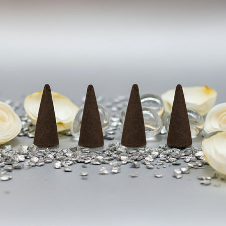 White Diamond Incense Cones on a reflective surface with decorative elements.
