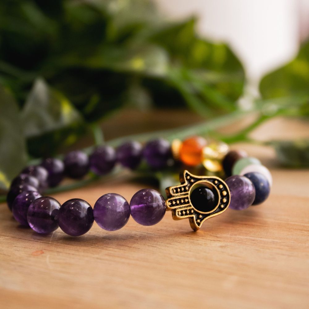 Ancient Infusions - Elevate your energy with our 7 Chakra Amethyst Hamsa Bracelet.