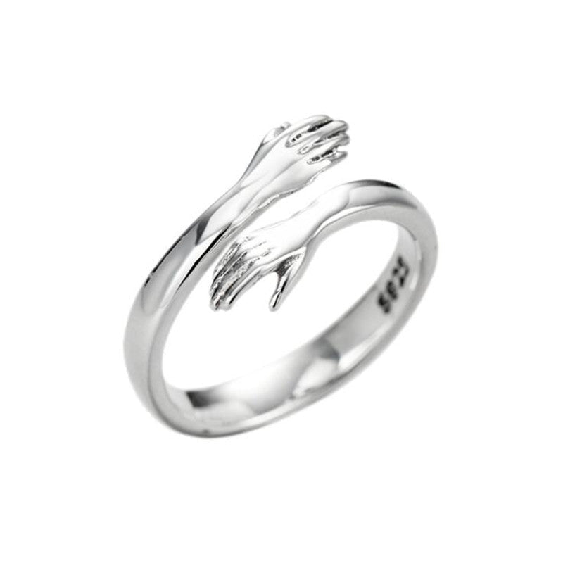 Ancient Infusions - Adjustable elegance: Hugging Hands Ring in timeless silver.