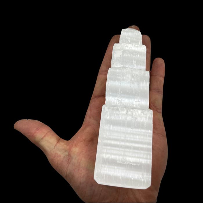 Front view of the Ancient Infusions Selenite Crystal Carved Geometric Tower emanating tranquil energy.