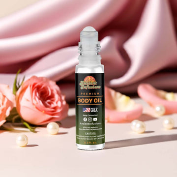 Baby Phat goddess inspired body oil bottle with roses and pearls on a pink fabric background