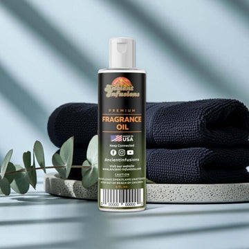 Black Ice Fragrance Oil bottle on a stone tray with eucalyptus leaves and black towels in the background.