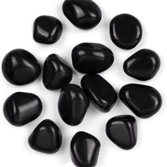 Close-up of Black Obsidian tumbled stones available for sale, emphasizing their protective energy.