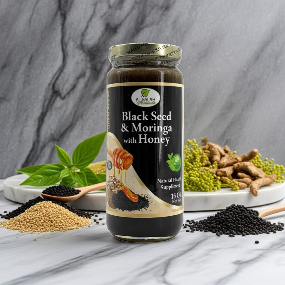 Jar of black seed and moringa honey with herbs on a white marble counter.