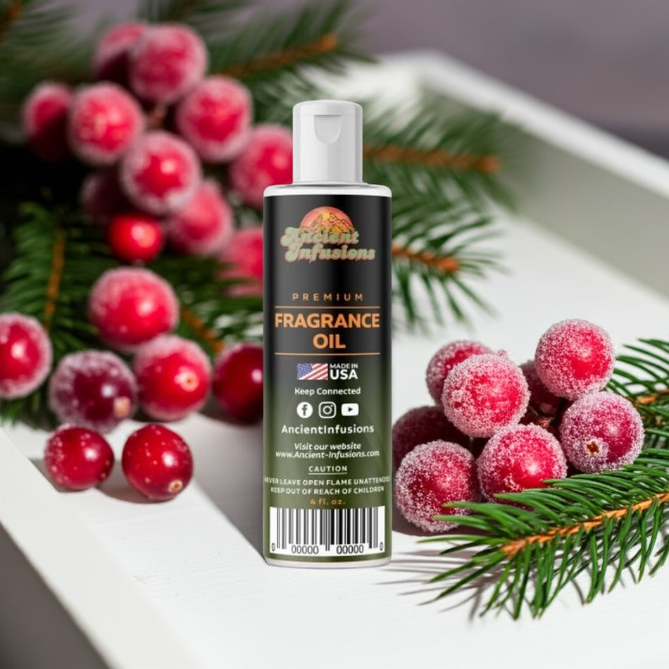 Bottle of Ancient Infusions fragrance oil with cranberries and greenery on a white surface