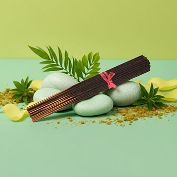 Cucumber Melon Incense Sticks with a pink tie on stones and leaves against a green background