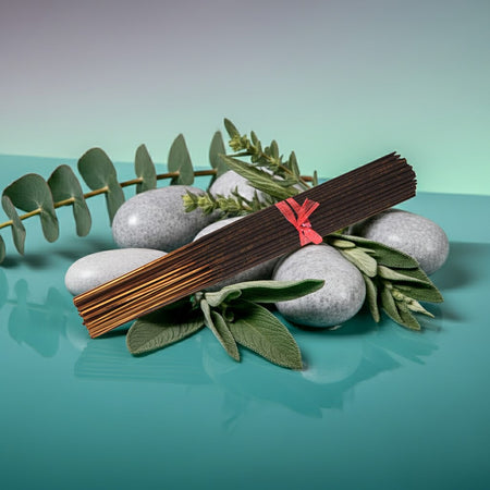 Eucalyptus Incense Sticks with a red tie on a green surface with stones and leaves