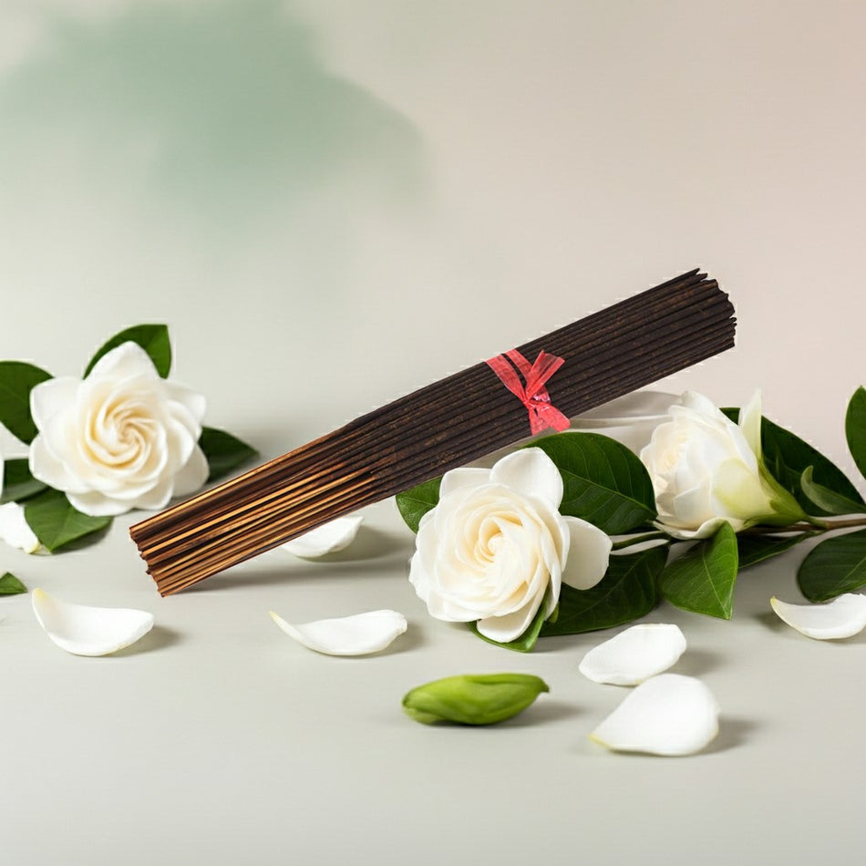 Gardenia Incense Sticks with a red label on a light surface with white flowers and green leaves.