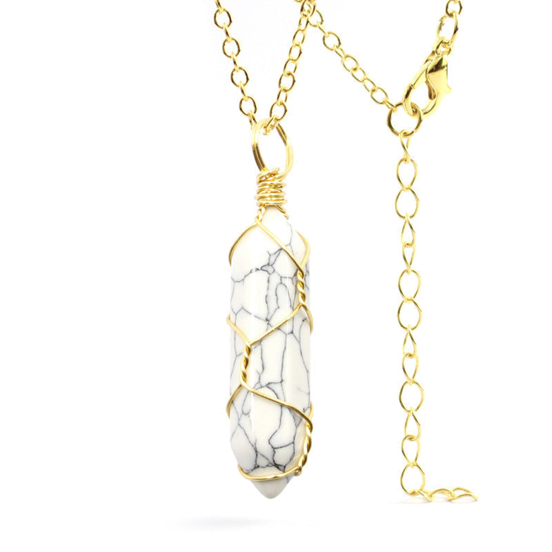 Close-up of a Howlite Necklace featuring a white gemstone with gray veining, wrapped in handcrafted gold wire with a stainless steel chain.