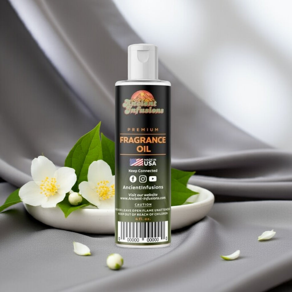 Bottle of Ancient Infusions fragrance oil with flowers on a gray fabric background