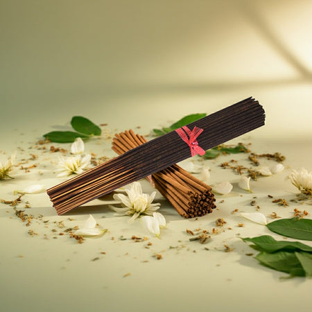 Jasmine Incense Sticks with a pink ribbon on a surface with flowers and leaves