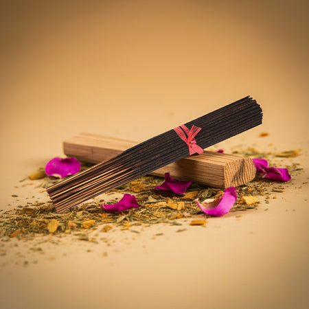 Nag Champa Incense Sticks with a wooden box on a beige background with pink petals and dried herbs.