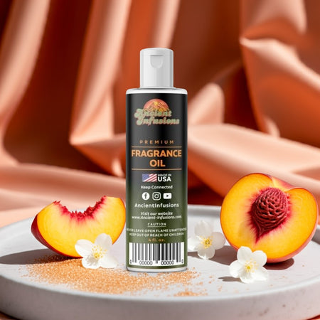 Bottle of Ancient Infusions fragrance oil with peach slices and flowers on a fabric background