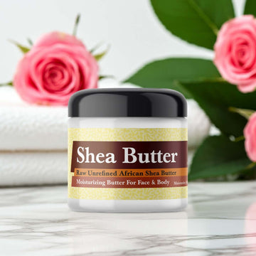 Black Woman Scented Shea Butter in a jar, enriched with natural ingredients, displayed with pink roses and green leaves, perfect for skin care.