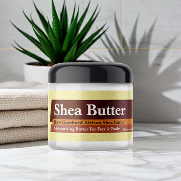 Jar of Egyptian Musk Scented Shea Butter on bathroom counter, aloe plant in background.
