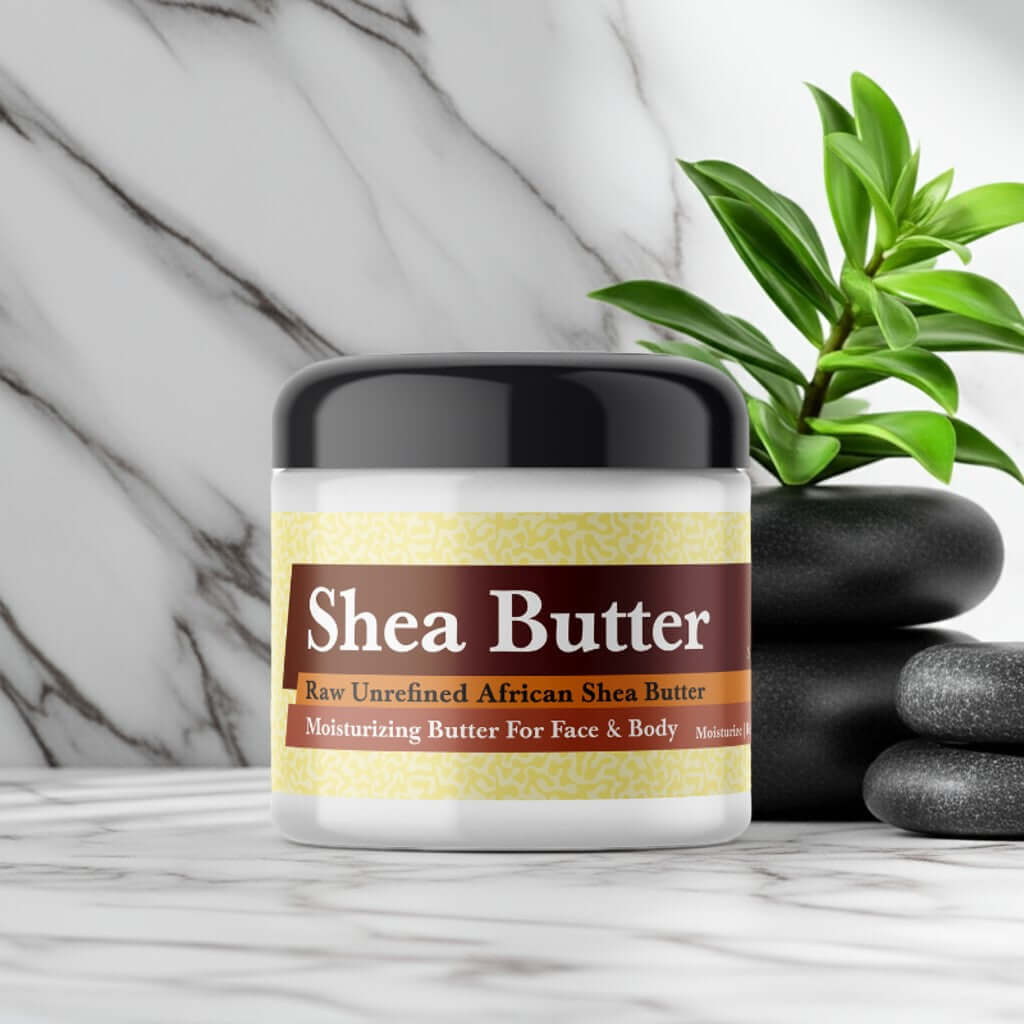 Jar of Jannatul Firdaus Scented Shea Butter on a marble surface with green leaves background