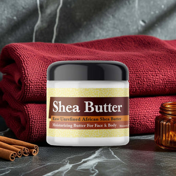 Joop Inspired Scented Shea Butter in a jar with red towels and cinnamon sticks.