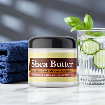Polo Blue Inspired Scented Shea Butter jar with cucumber water and towels on marble surface.
