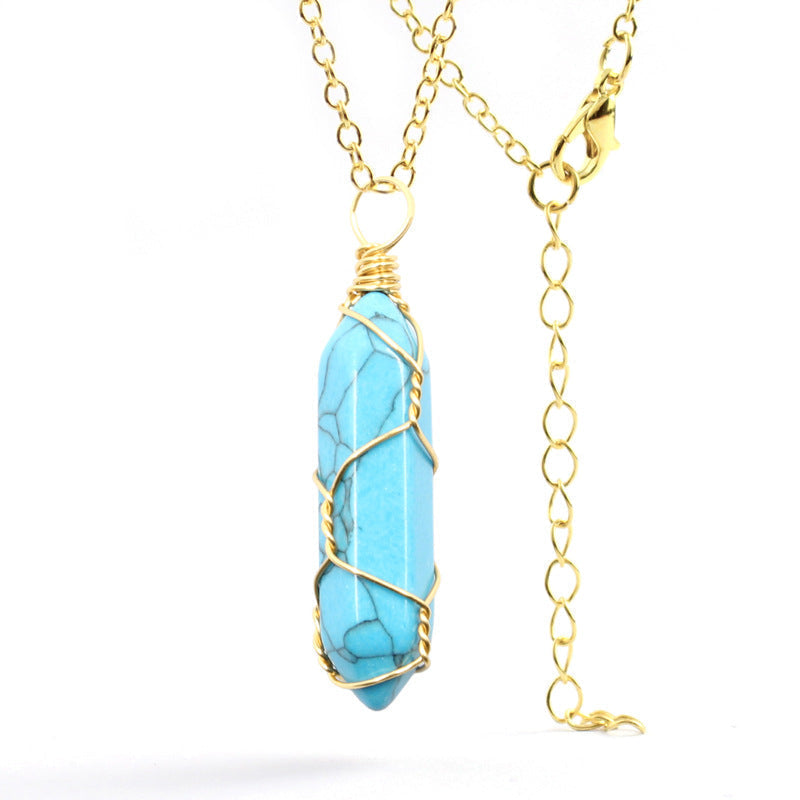 Close-up of a Turquoise Necklace featuring a vibrant gemstone wrapped in handcrafted gold wire with a stainless steel chain.